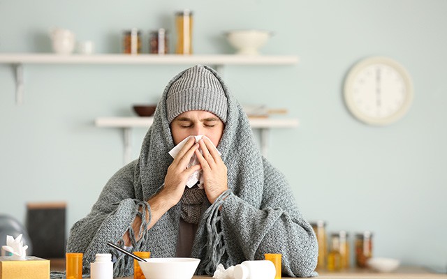 Mann mit Erkältung putzt sich die Nase
